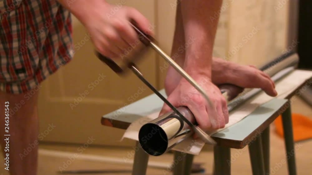 a man cuts a metal leg for the table a man cuts a metal leg for the table