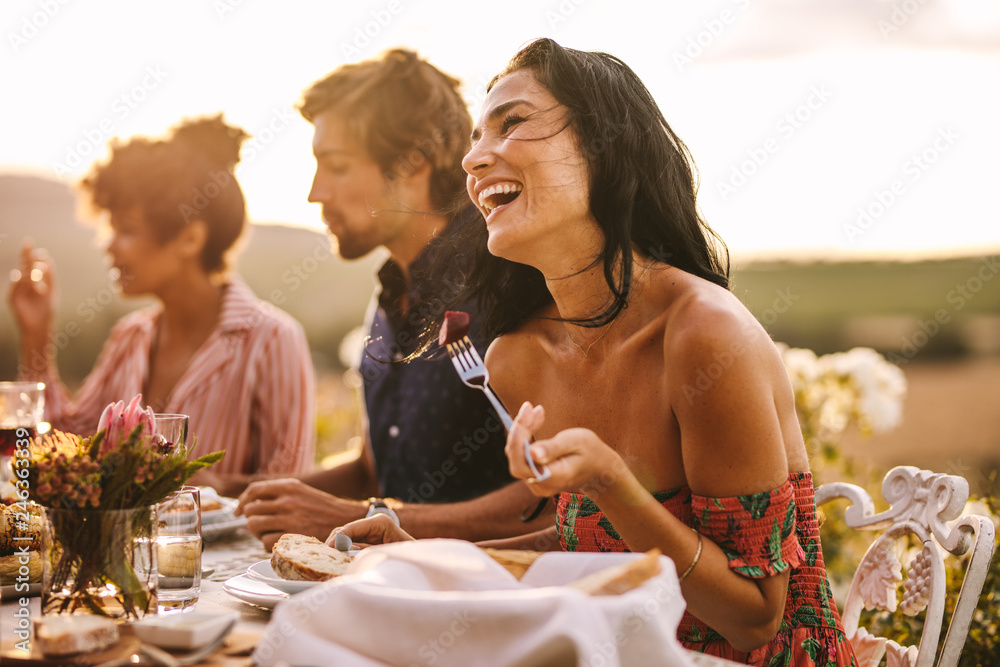 Woman enjoying with friends at outdoor dinner party - obrazy, fototapety, plakaty 