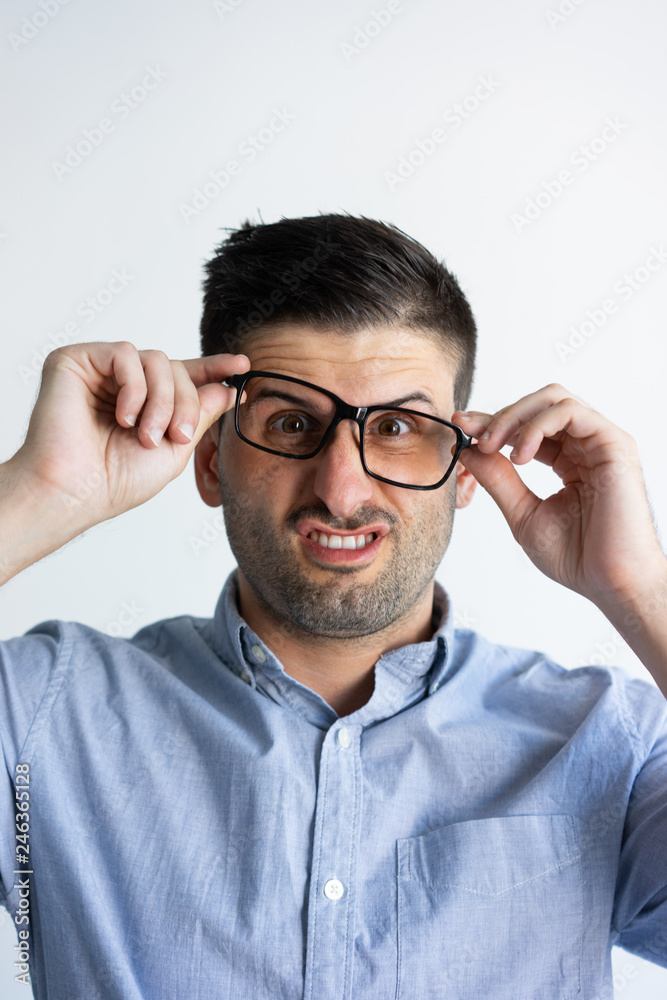 Crazy angry guy with stubble having troubles with eyeglasses wearing.  Annoyed young Caucasian man putting on glasses in wrong way. Negative  emotion concept Stock Photo | Adobe Stock