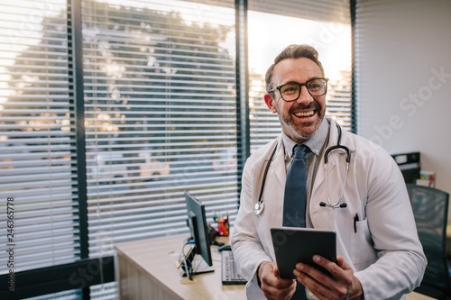 Fotografia, Obraz Doctor with digital tablet in his office