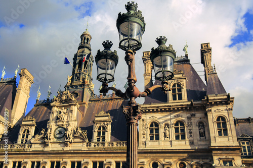 Hotel de Ville in Paris, France. Historic building housing the city's local administration. Facade of city hall and vintage lantern in spring. French municipality.