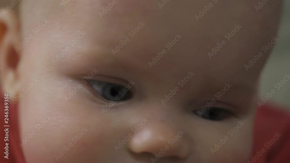 A little one-year-old girl sucks her fingers. Her teeth are pierced. The child looks into the camera. A little one-year-old girl sucks her fingers. Her teeth are pierced. The child looks into the camera.