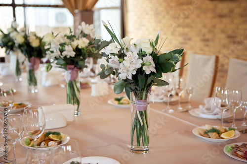 Wedding table decorated with flowers. Table setting for a banquet before the meal. Beautiful table setting on a holiday.