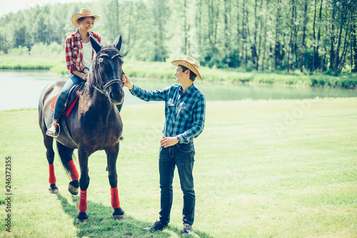 Couple riding a horse in the farm in cowboy style. Sport, happiness, hobby concept