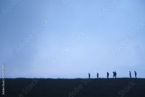 People walking on ridge in silhouette