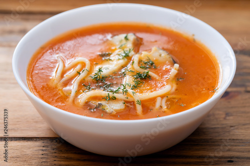 fish soup in the white bowl on wooden background