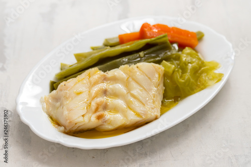 boiled cod fish with vegetables on white dish