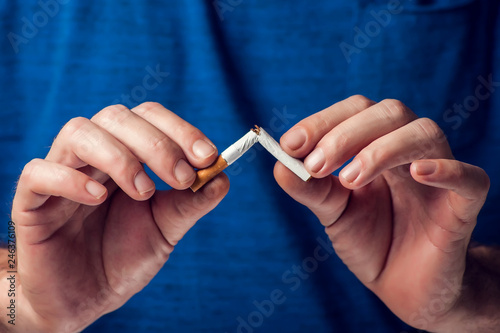 Stop smoking cigarettes concept. Broken cigarette in hands. Quit bad habit  health care concept. No smoking.