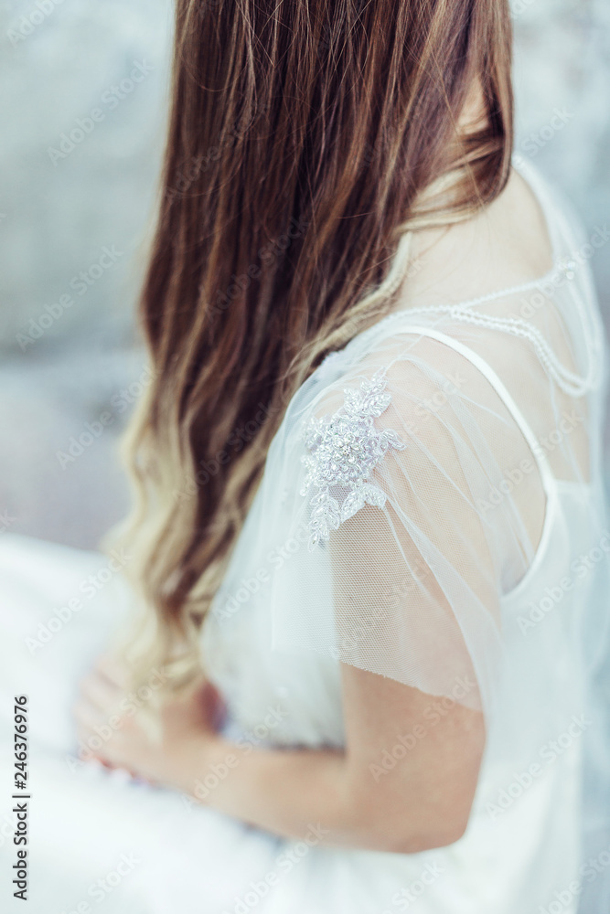 Back view of young slim elegant girl in wedding dress Back view of young slim elegant girl in wedding dress
