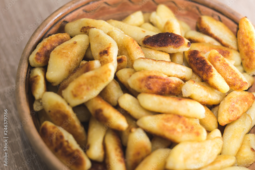 Sticks of dough and potatoes fried to crust in a wooden bowl Sticks of dough and potatoes fried to crust in a wooden bowl