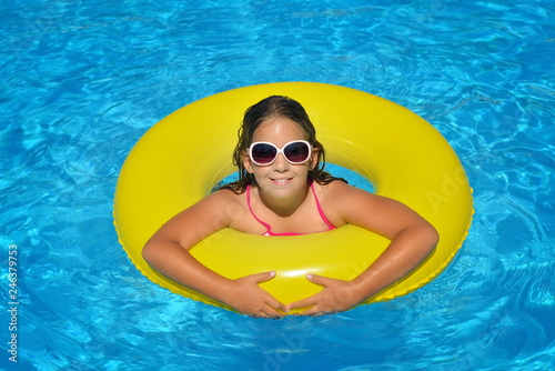 Real adorable girl relaxing in swimming pool