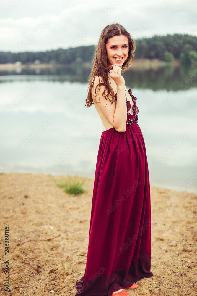 Freedom beauty young woman in sexy dress outdoors near the lake walking and posing Freedom beauty young woman in sexy dress outdoors near the lake walking and posing
