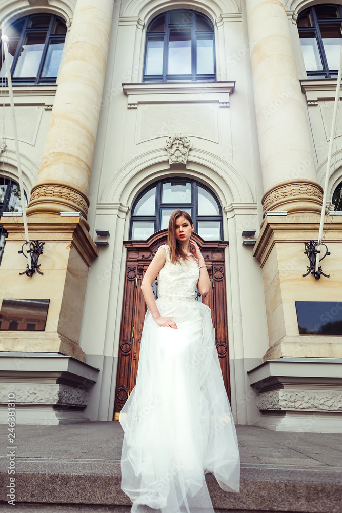 Gorgeous elegant caucasian young lady posing outdoors in old town in fashionable wedding dress. Beauty, fashion, vogue concept