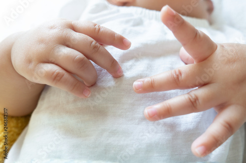 Newborn baby hands on a white shirt  baby hands and nails