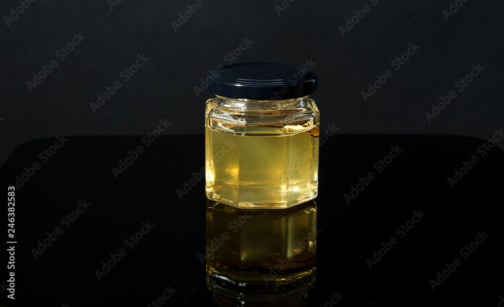 truffle mushroom in a jar of honey on a black background. Minimalism in composition. Luxury food. Free space for text. truffle mushroom in a jar of honey on a black background. Minimalism in composition. Luxury food. Free space for text.