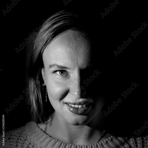 Stylish portrait of an attractive caucasian woman. Black and white shot, low-key lighting. Isolated on black.