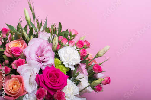 beautiful floral arrangement in the box, pink and yellow rose, pink eustoma, green and pink chrysanthemum, white carnation, pink dahlia on pink background with space for text. © Alex