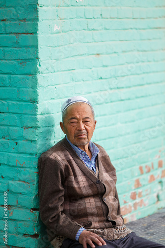 Photography old uigur resting in a corner, china