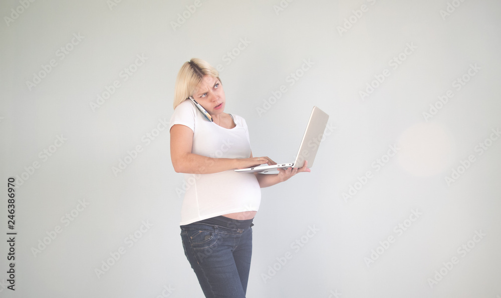 Young beautiful pregnant woman working on laptop. Pregnant business woman searching information and online shopping on laptop prepare for childbirth and parenting on sofa at home Young beautiful pregnant woman working on laptop. Pregnant business woman searching information and online shopping on laptop prepare for childbirth and parenting on sofa at home