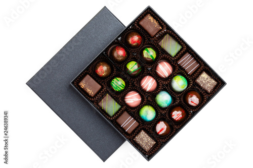 Assortment of luxury bonbons with colorful splashes in black box isolated on white background © torriphoto