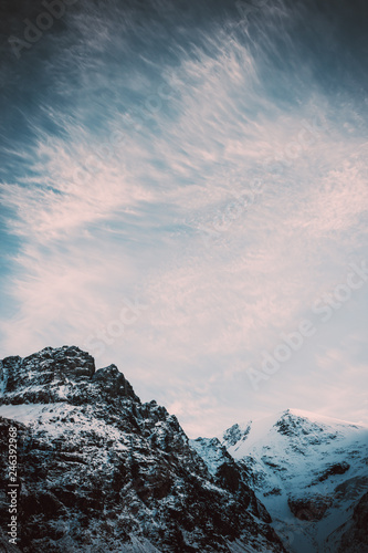 Severe mountain peaks under snow. Dark atmosphere of nature.