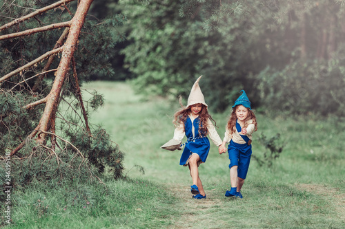 Cute girls gnomes in forest playing and having fun. Friendship, childhood concept