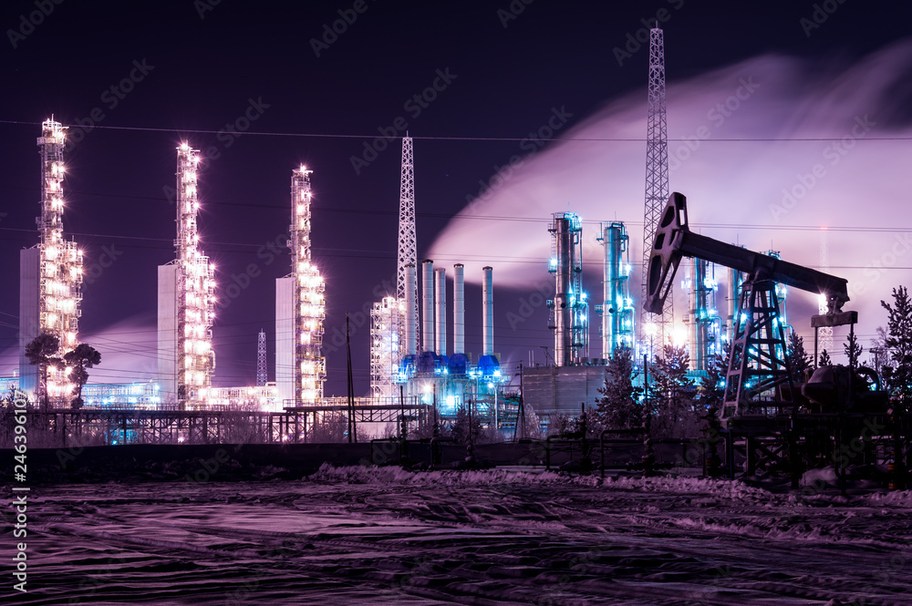 Pump jack and refinery night. Chemical industry distillation towers detail  at night. Oil gas theme. Stock Photo