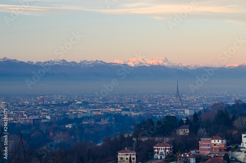 anorama of Turin at dawn, overlooking the city center and the Mole Antonelliana, a backdrop of snow-capped mountains illuminated by pink light photo