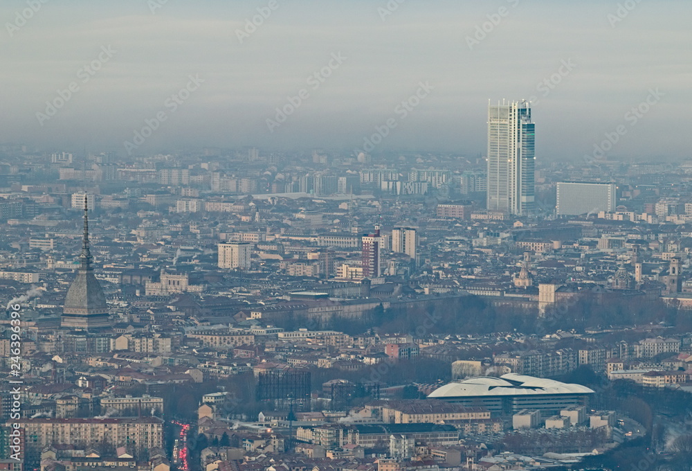 Panoramic view at sunrise on Turin city seen from Superga in winter, with a layer of smog that falls on buildings