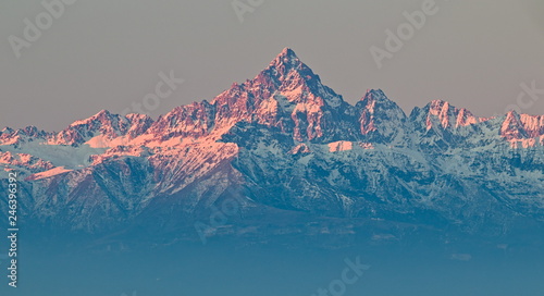 Mount Viso, Alps peak, seen from Superga, Turin, Piedmont, during a winter sunrise with snow and pink light on the glaciers