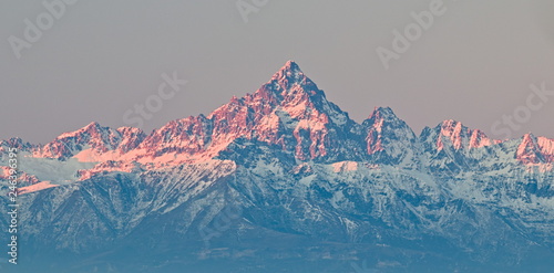 Mount Viso, Alps peak, seen from Superga, Turin, Piedmont, during a winter sunrise with snow and pink light on the glaciers
