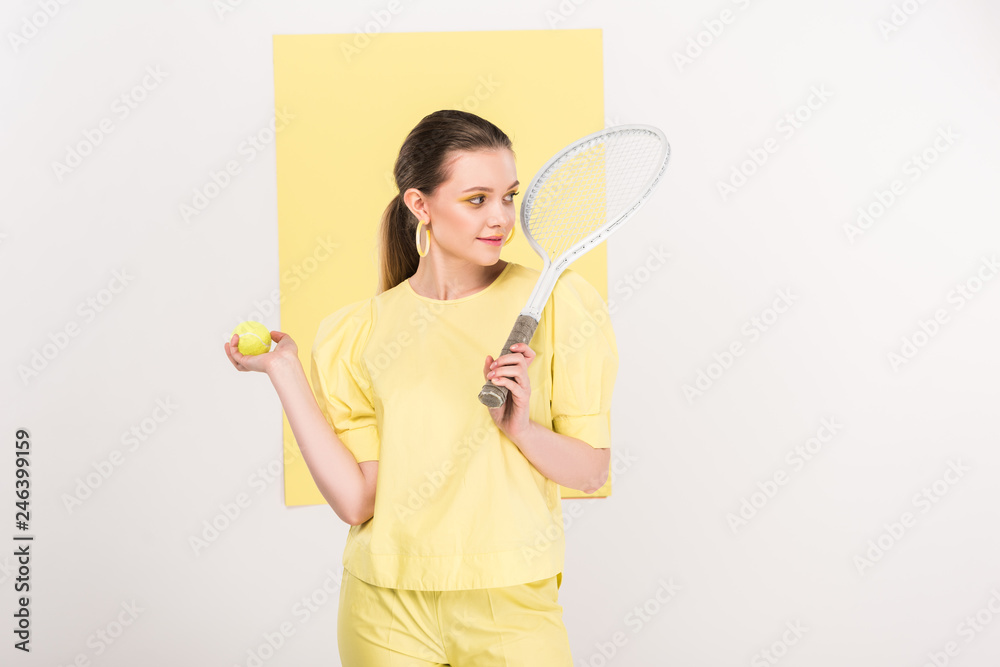 beautiful stylish girl holding tennis racket and ball while posing with limelight on background beautiful stylish girl holding tennis racket and ball while posing with limelight on background