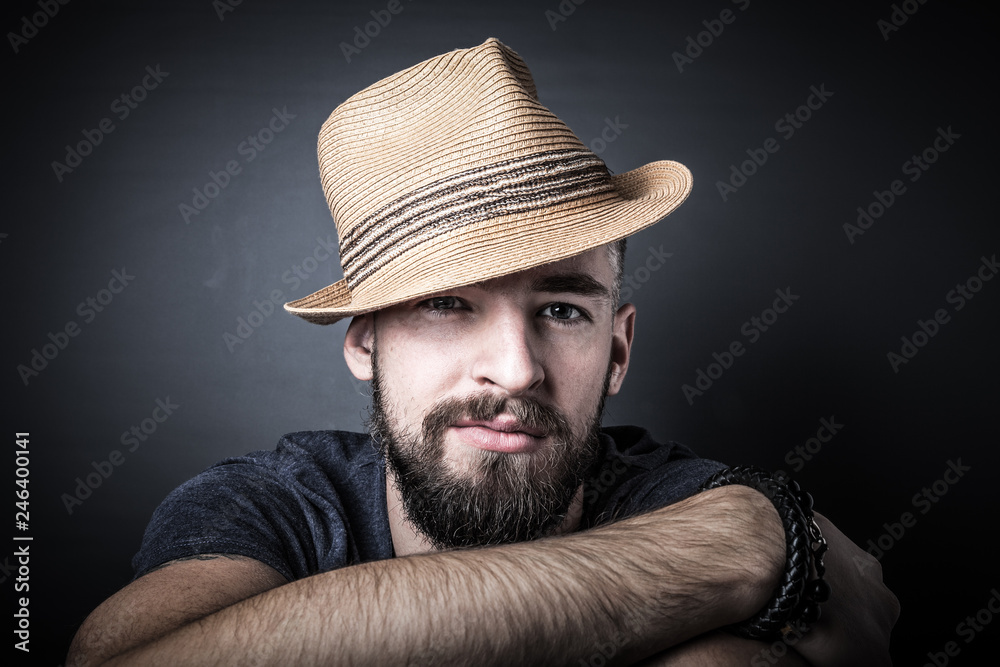 Portrait of a young man with a beard and hat. Toned Portrait of a young man with a beard and hat. Toned