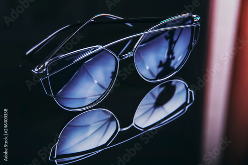 Sunglasses on a black mirror background