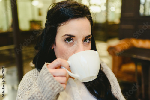 Pretty brunette woman drinking coffee in Vienna, European city, during a trip.