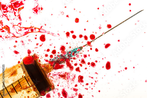 Close up view of syringe and blood on white