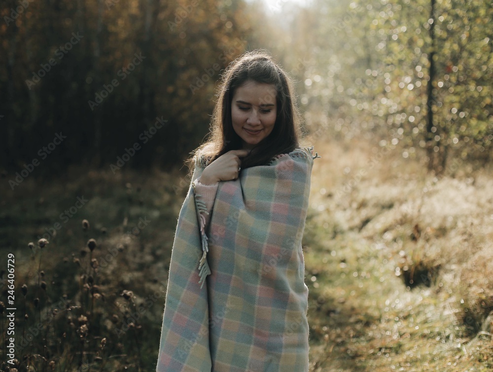 Beautiful cheerful girl in the autumn park. Walk in the park, the girl is wrapped in a blanket. Autumn landscape Beautiful cheerful girl in the autumn park. Walk in the park, the girl is wrapped in a blanket. Autumn landscape