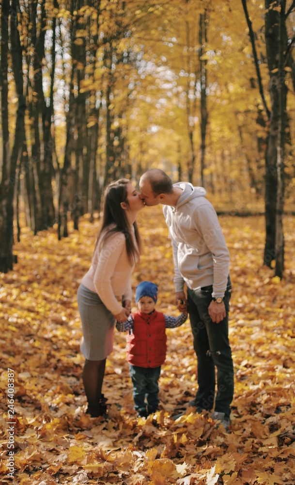 Mom and dad kiss each other.Son between parents. Happy family