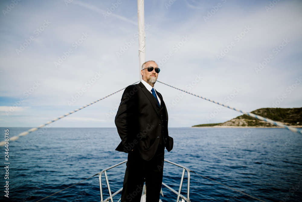 Geschäftsmann steht am Bug eines Segelbootes