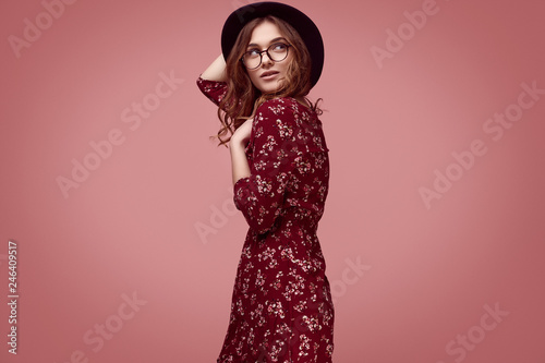 Elegant glamor hipster girl in red fashion dress, black hat and glasses