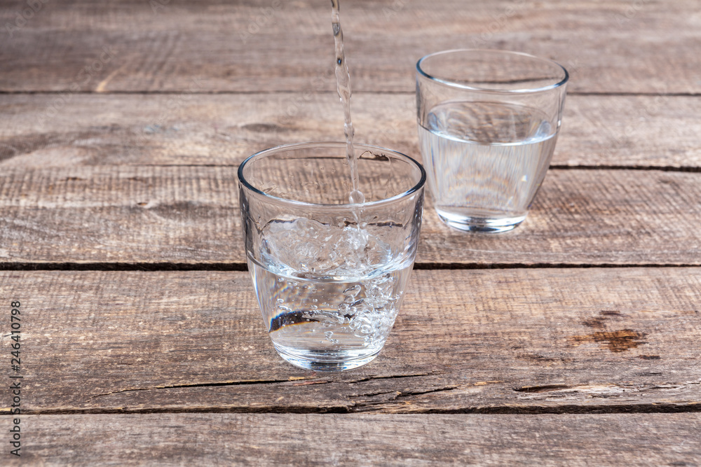 Glasses of water on a wooden table. Glasses of water on a wooden table.