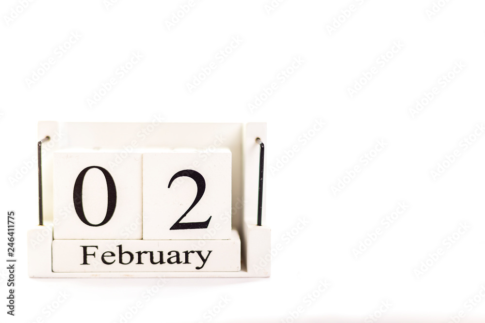 the day of February on a white clear background. a wooden desktop calendar that reminds us of what date we are today. the day of February on a white clear background. a wooden desktop calendar that reminds us of what date we are today.