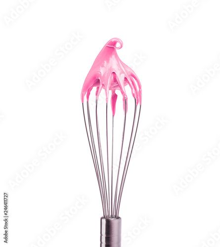 Metal whisk with pink cream isolated on black background. Clipping path. photo