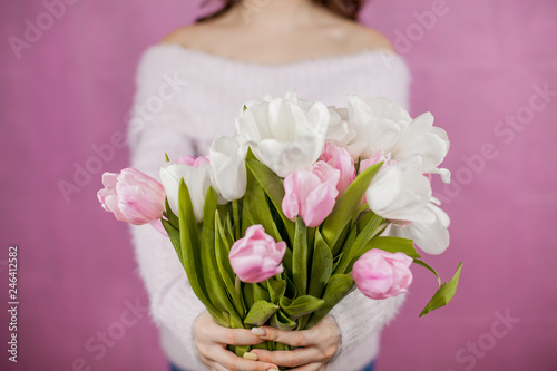 Close-up Young woman holding Bouquet of pink Tulips Pink background Spring Holidays
