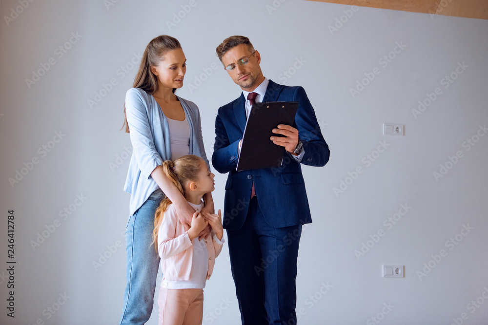 attractive mother hugging daughter while standing near broker attractive mother hugging daughter while standing near broker