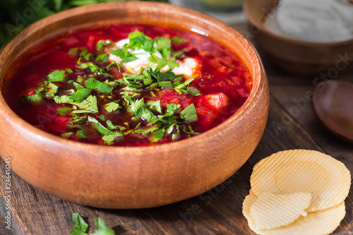 Beet soup in a wooden plate on a wooden table. Rustic style