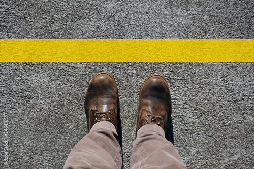 man's shoes view from above and a a limit line