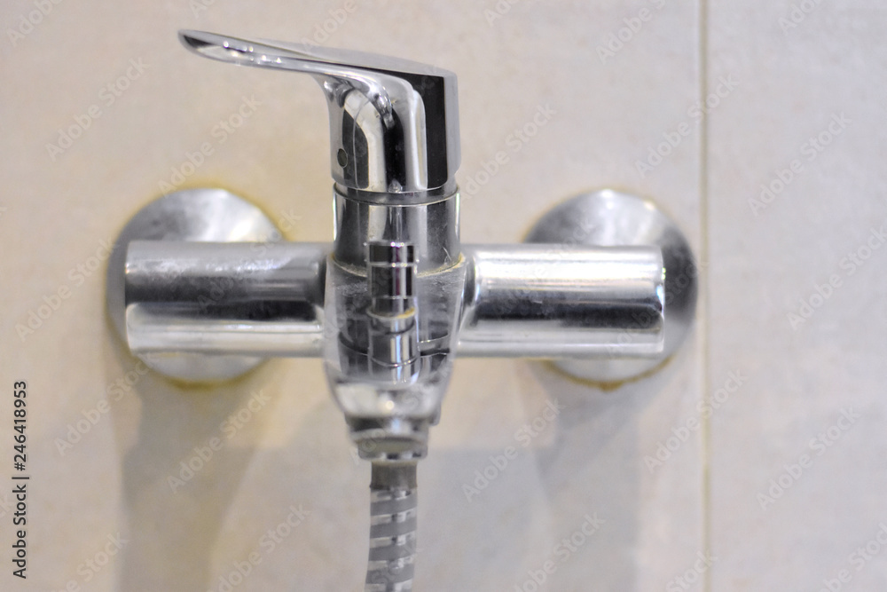 Dirty chrome faucet with selective focus on blurred background. Steel bathroom faucet with dirty silver surface. Mold or fungus at the blurred bathroom wall. Stainless design shower Dirty chrome faucet with selective focus on blurred background. Steel bathroom faucet with dirty silver surface. Mold or fungus at the blurred bathroom wall. Stainless design shower