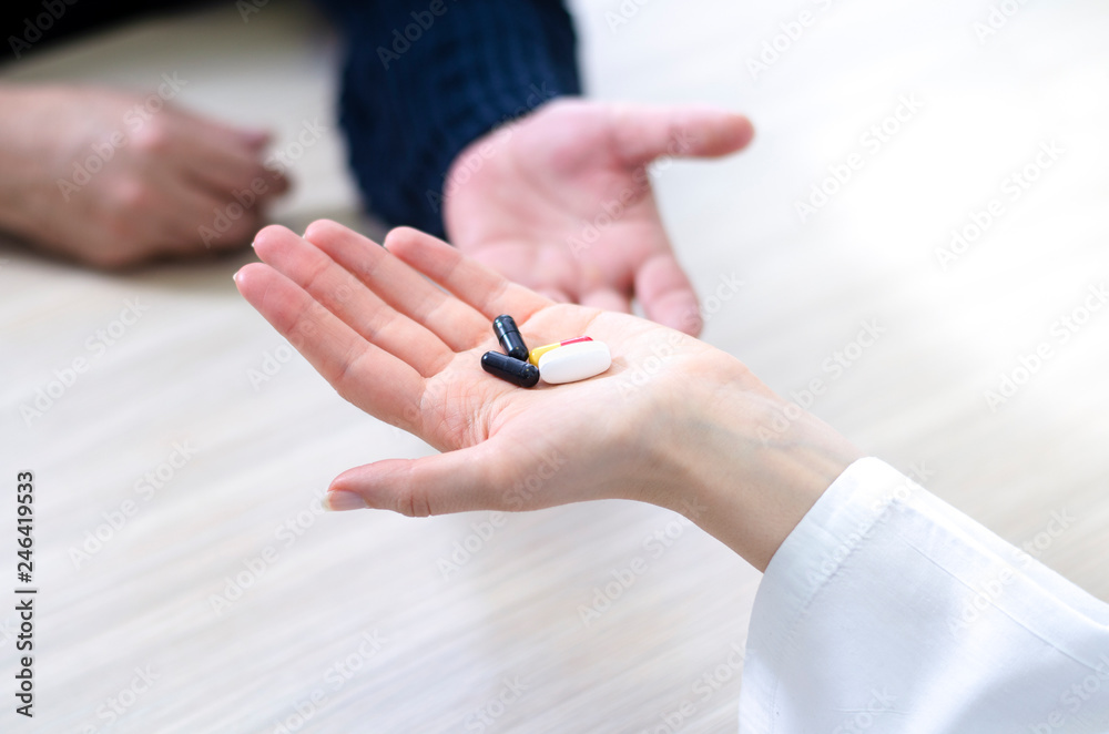 Closeup of doctor's palm holding pills for the elderly patient Closeup of doctor's palm holding pills for the elderly patient