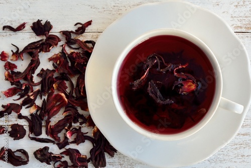 Cup of tea with hibiscus flowers on white background close-up